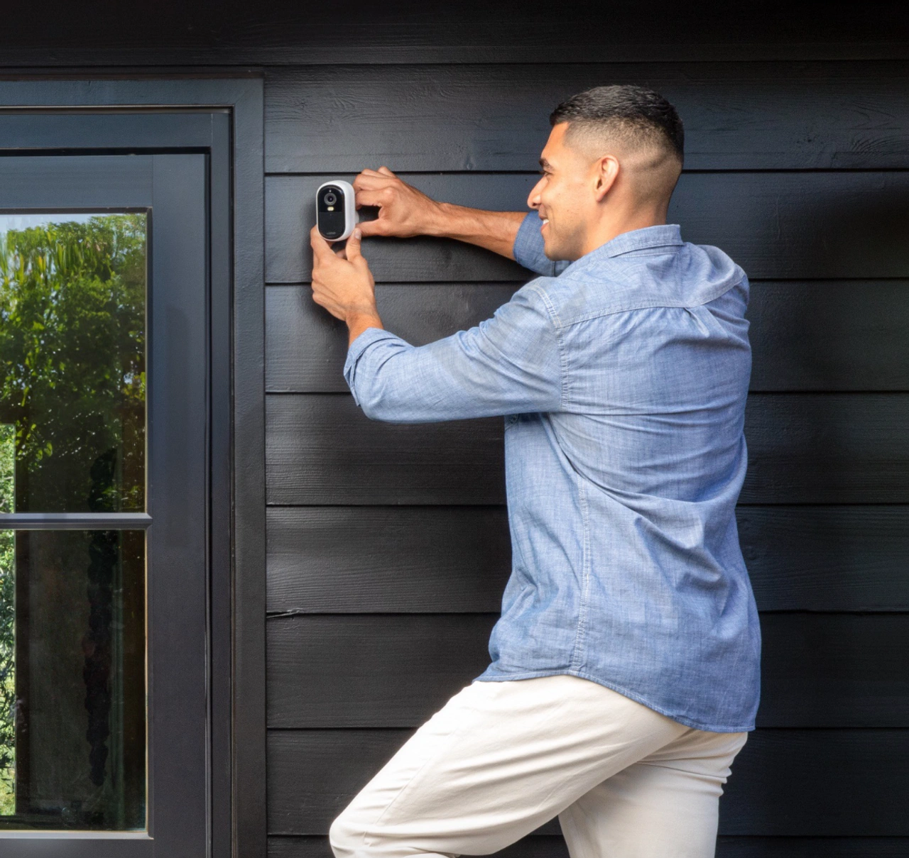 Blick eines Mannes, der die neue Arlo Outdoor-Kamera an einer Wand anschraubt (Foto: Arlo)