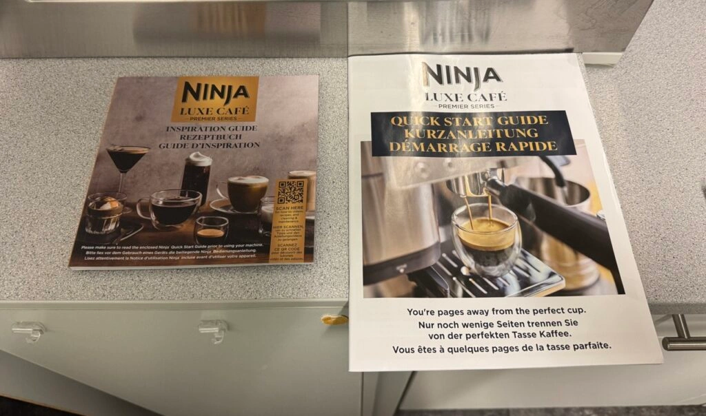 Rezeptbuch und Quick Start Guide der Ninja ES601EU nebeneinander auf einem Küchentresen.