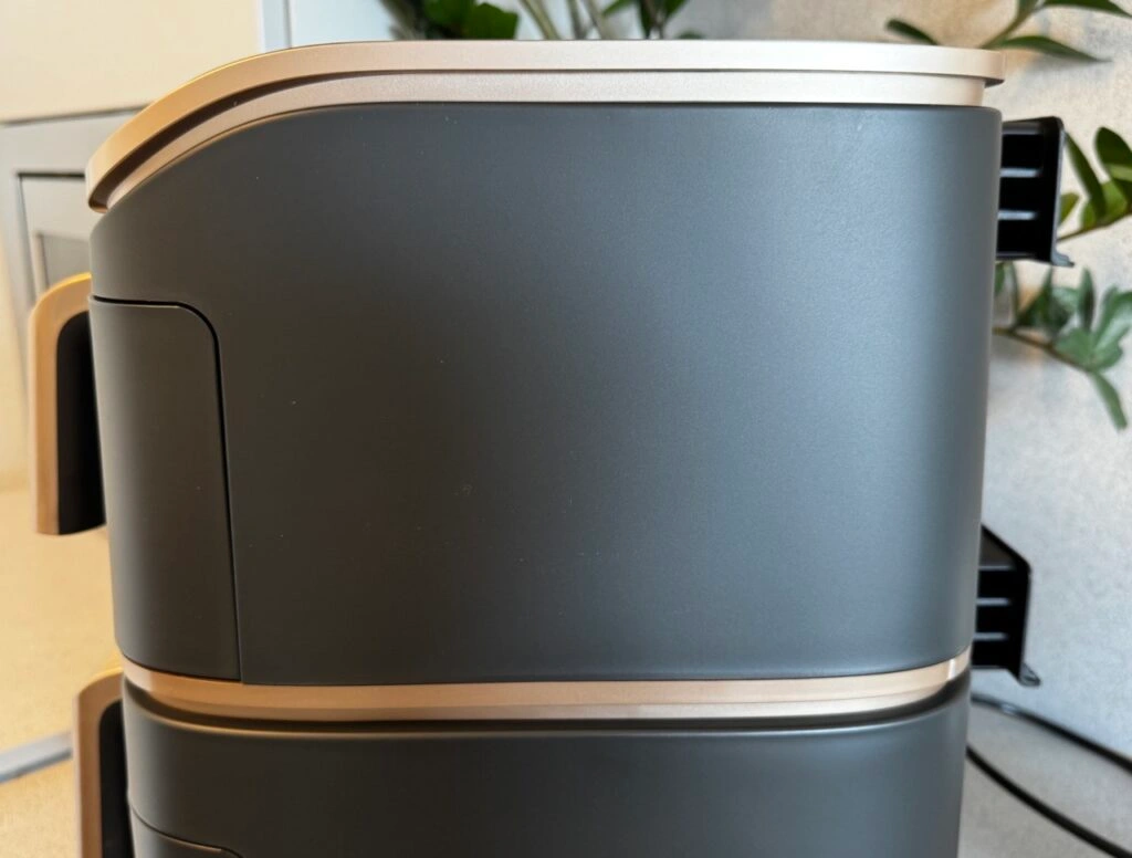 Seitenansicht der Cosori Turbo Tower Pro mit elegantem Gehäuse und zwei goldenen Griffen in vertikaler Anordnung.