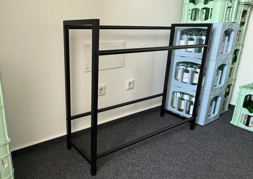 Leeres STEELSØN Macondo Getränkekistenregal aus schwarzem, pulverbeschichtetem Metall, frontal aufgenommen.