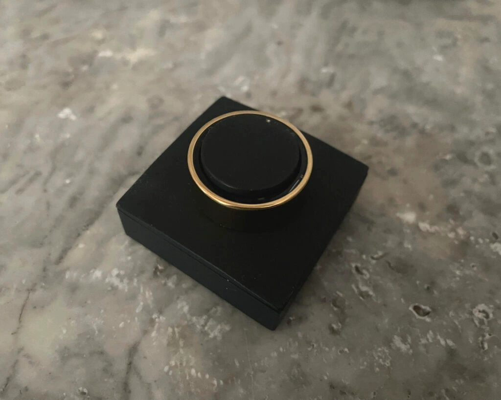 UltraHuman Ring AIR in der Farbe Bionic Gold auf der schwarzen Ladestation.