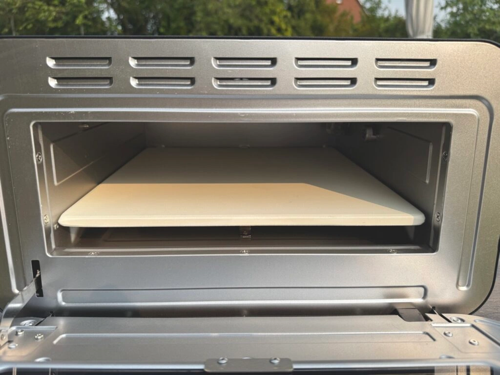 Geöffneter Pizzaofen mit innenliegendem Stein.