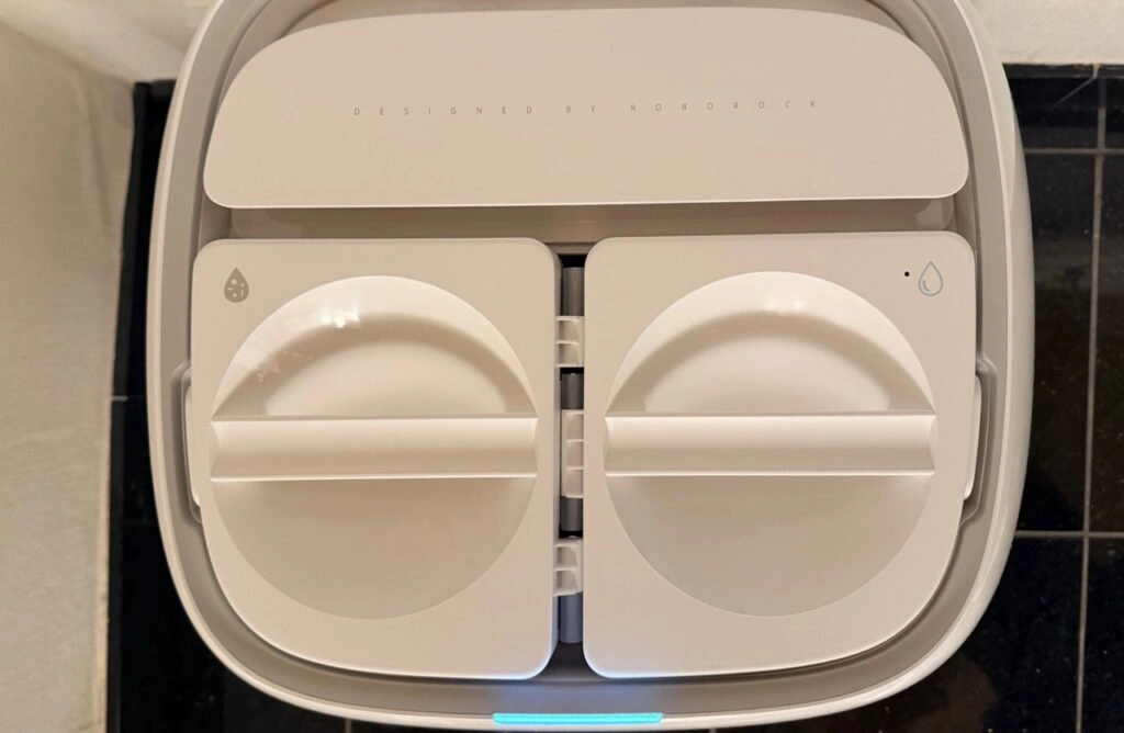 Roborock Qrevo Curv 2 Flow: Draufsicht in die geöffnete Reinigungsstation mit Frisch und Schmutzwasserbehälter