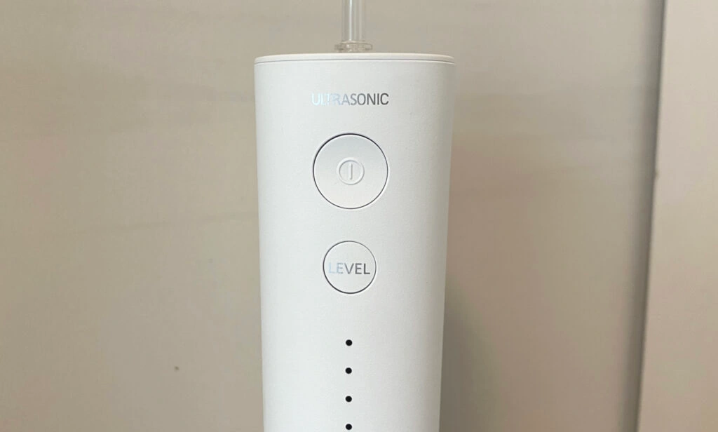 Nahansicht der Bedienelemente der Panasonic Munddusche, die einen Power-Knopf sowie einen Button zur Einstellung der Leistungsstufe enthält (Foto: Testsieger.de)