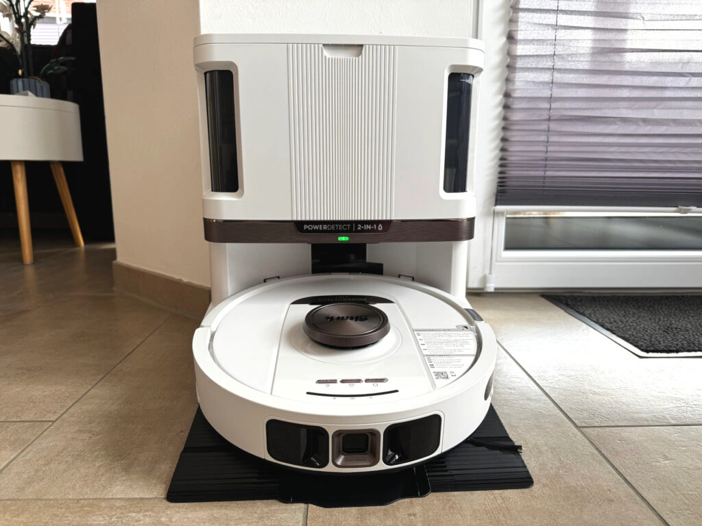 Der Shark PowerDetect NeverTouch Pro 2-in-1 Saug- und Wischroboter steht in seiner vollautomatischen Reinigungsstation. Das Modell in Weiß mit silbernen Akzenten ist dezent designt und fügt sich nahtlos in moderne Wohnräume ein. (Foto: Testsieger.de)