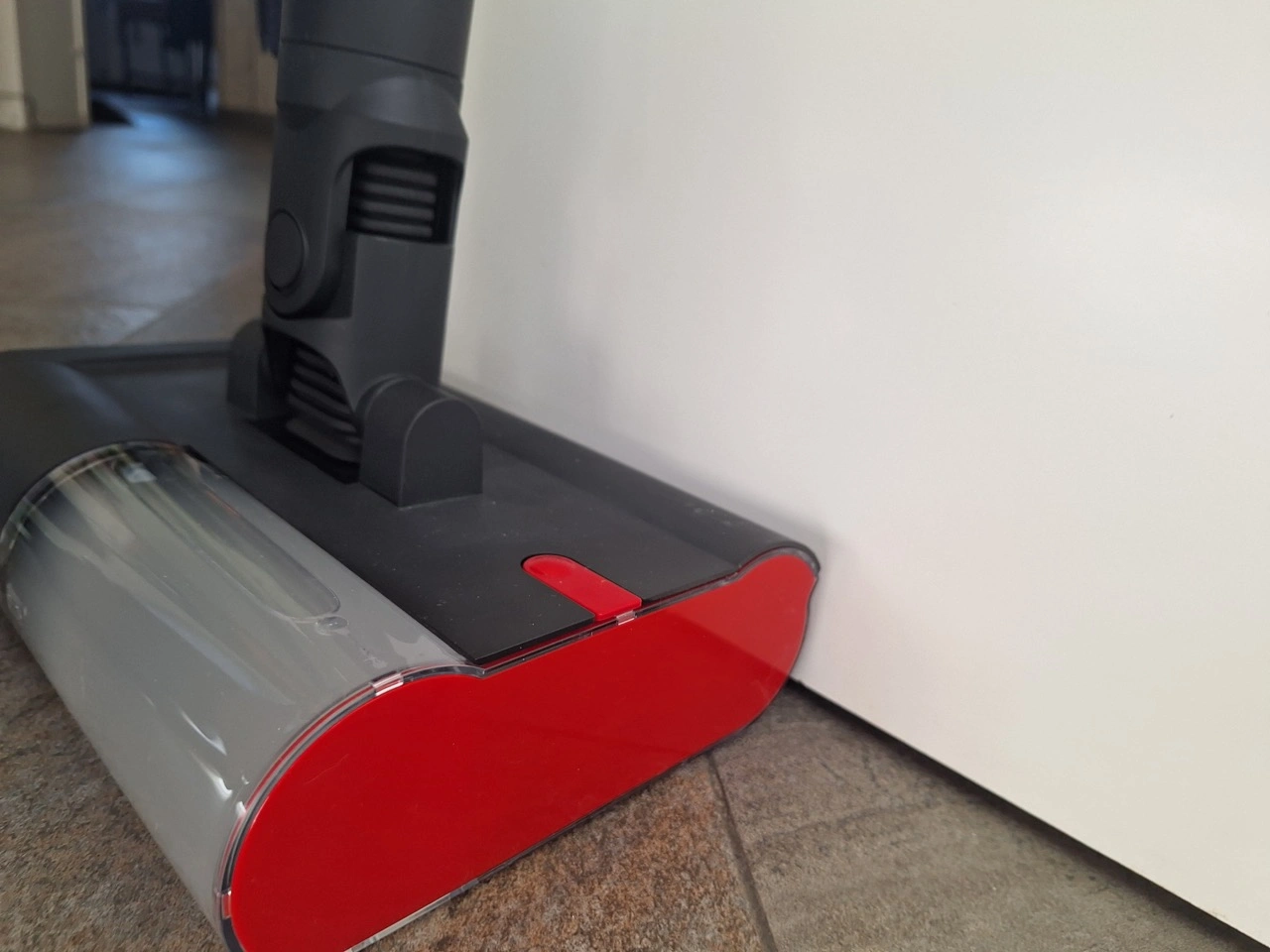 Dyson PencilWash: Reinigungskopf an einer Kante mit roter Seitenabdeckung