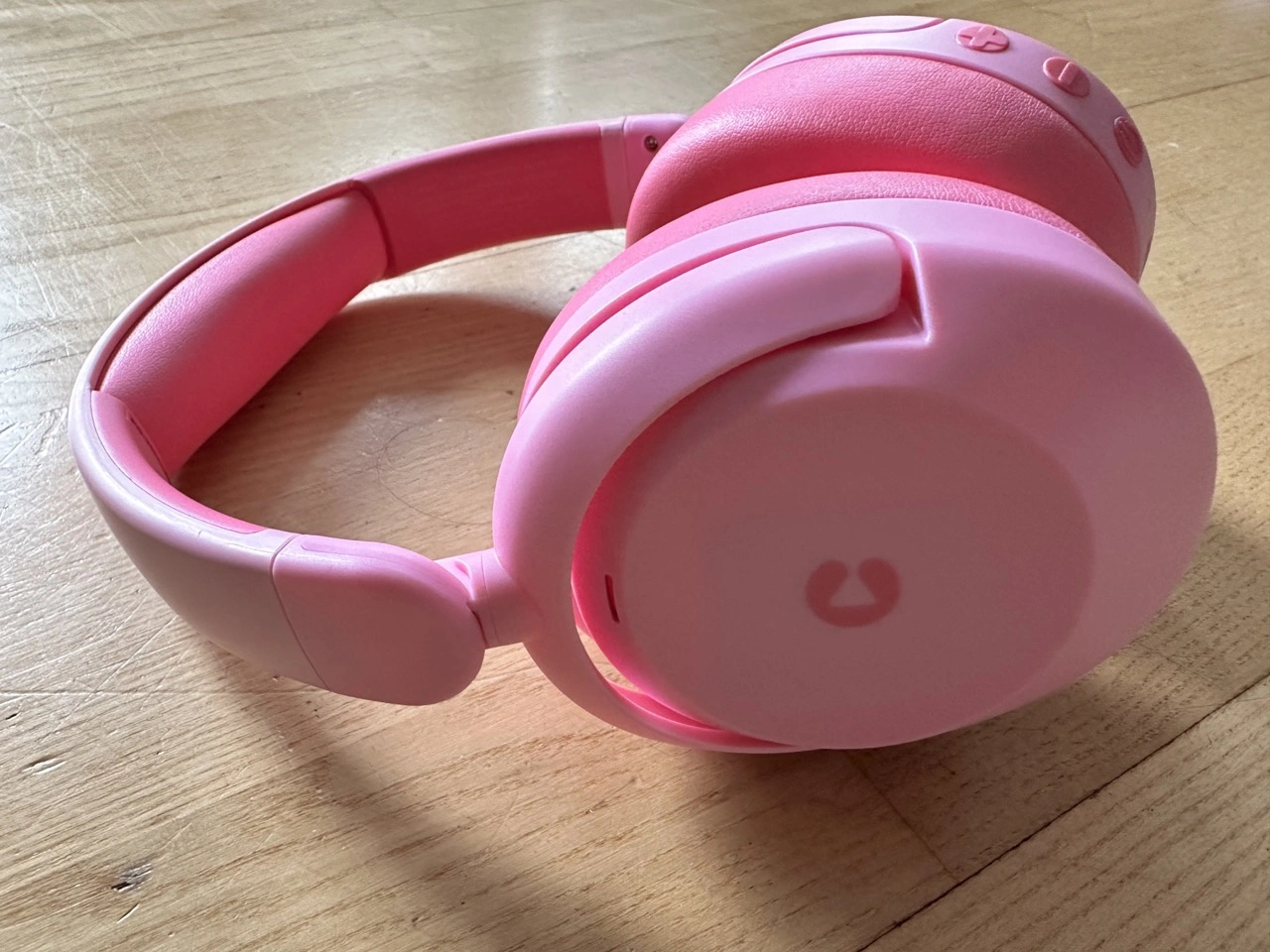 iClever BTH20: Kinderkopfhörer in Pink auf Holzoberfläche