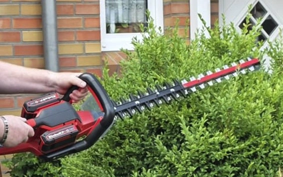 Einhell Akku-Heckenschere GE-CH 36-65 Li-Solo: Heckenschere mit Akkus auf Gartentisch