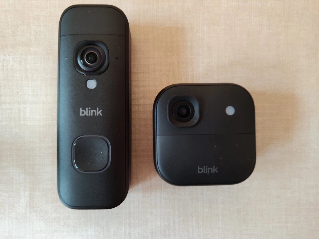 Blink Outdoor 2K+ Kamera und Blink Videotürklingel 2K+: Außenkamera und Videotürklingel nebeneinander