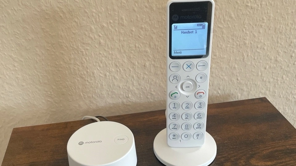 Motorola DOT411: weißes Mobilteil in der Ladeschale neben der Basis