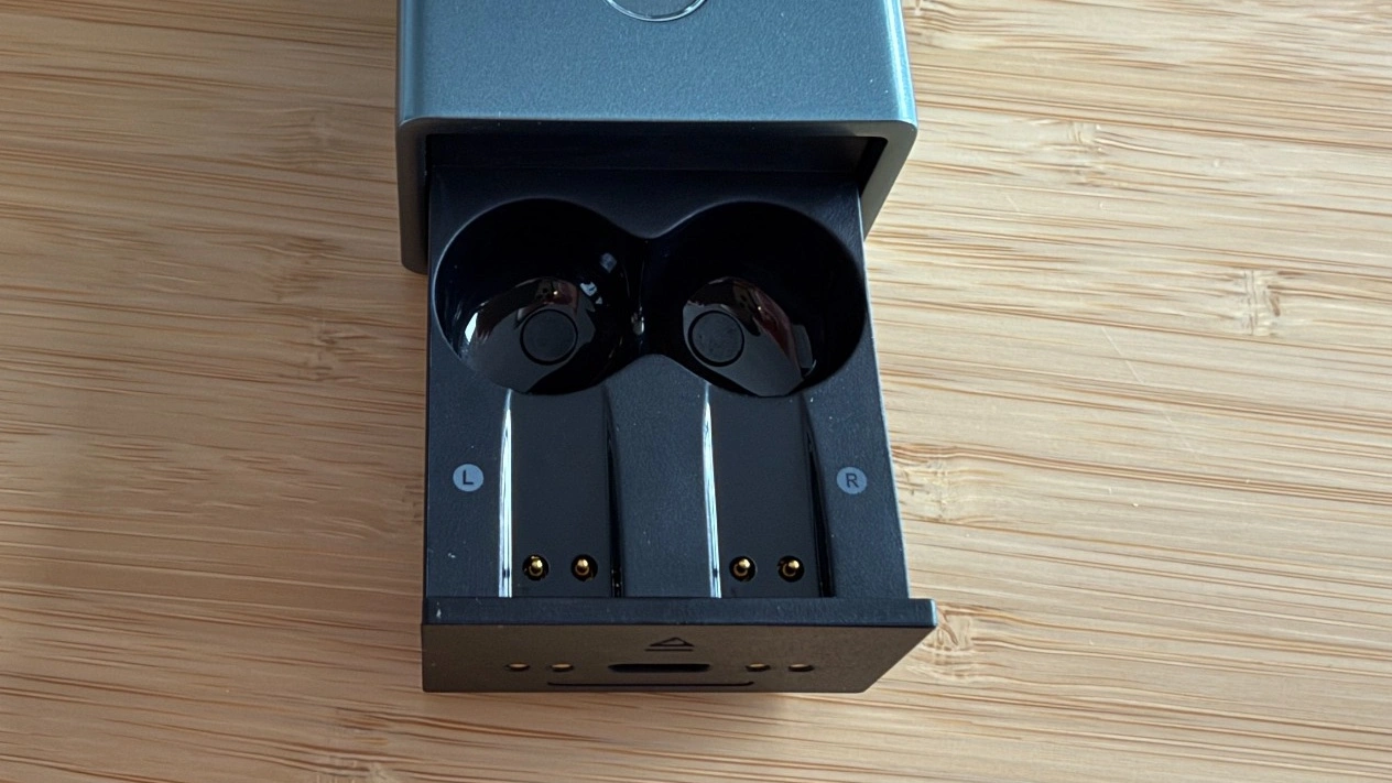 Timekettle X1 Meeting: Geöffnete Ladeschublade mit Ohrhörern und Ladekontakten