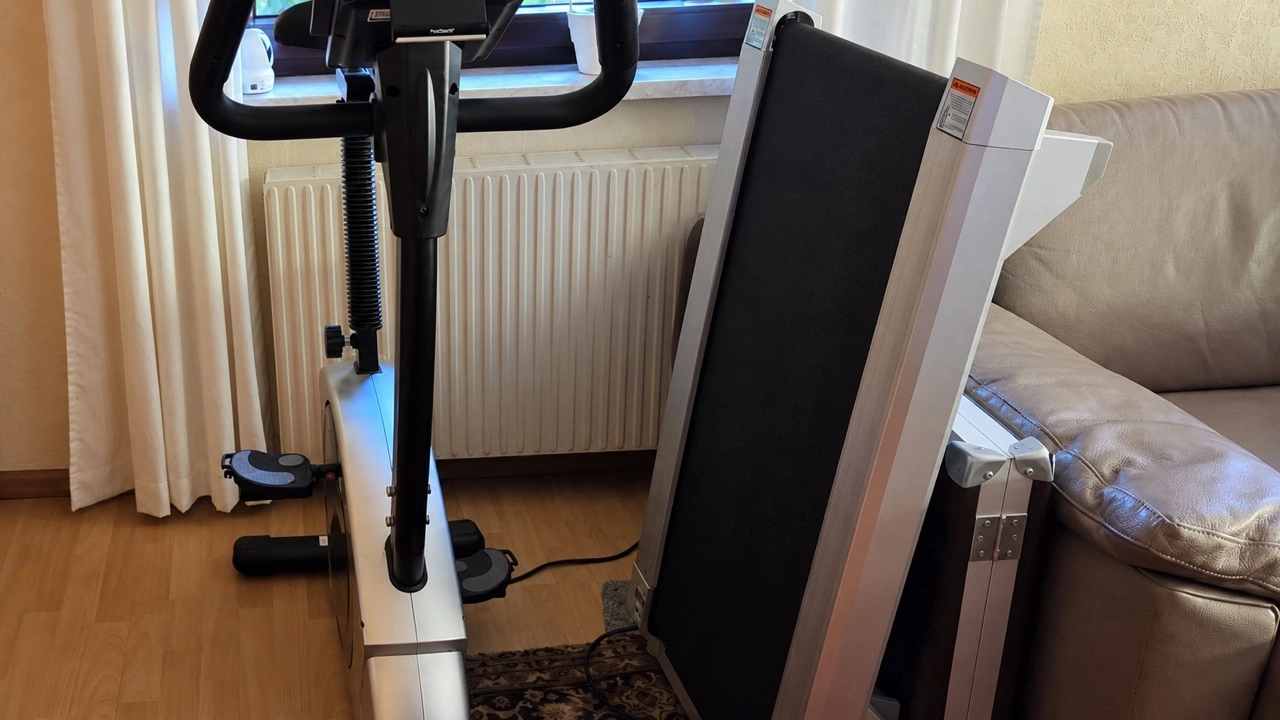 UREVO CyberPad for Office: Hochkant abgestelltes Walking Pad neben einem Ergometer