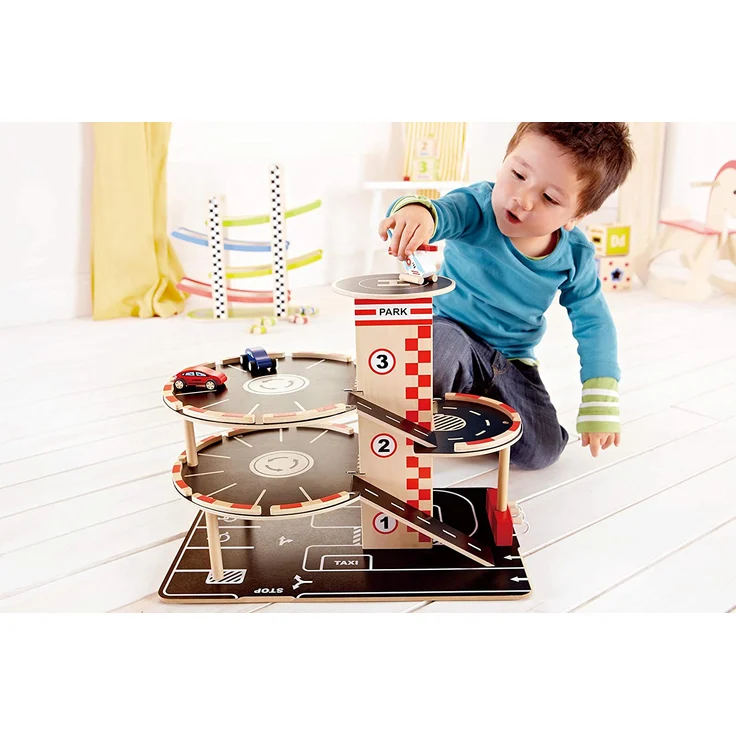 Hape Parkhaus aus Holz für Kinder Spieleset Autogarage | Auffahrrampe mit drei Parkdecks und einem Hubschrauber-Landeplatz, 2 Spielzeugautos, 1 Spielzeug-Hubschrauber, ein Aufzug und eine Tankstelle – Bild 2